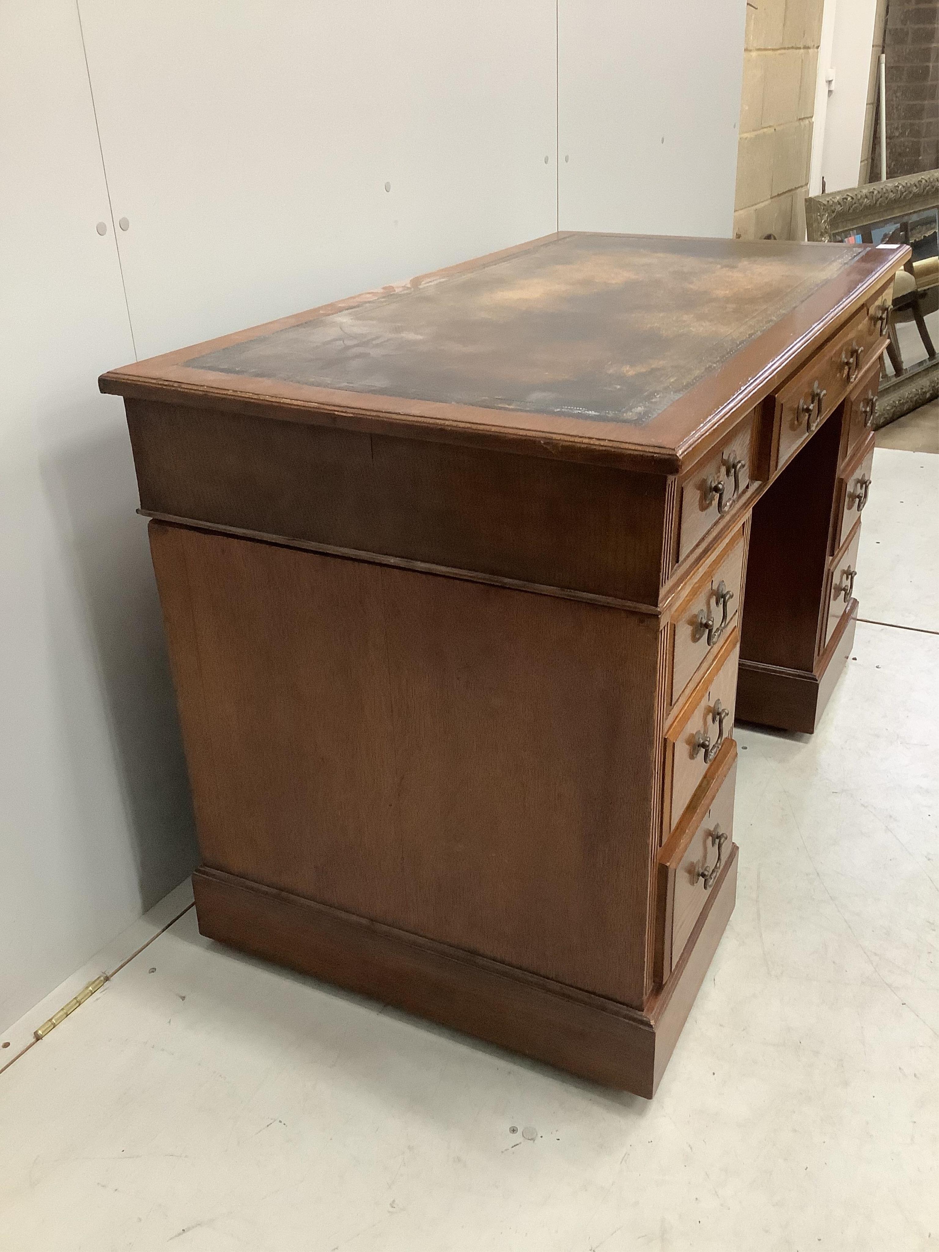 An early 20th century oak pedestal desk, fitted nine drawers, with a leather inset top, width 121cm, depth 64cm, height 78cm. Condition - fair